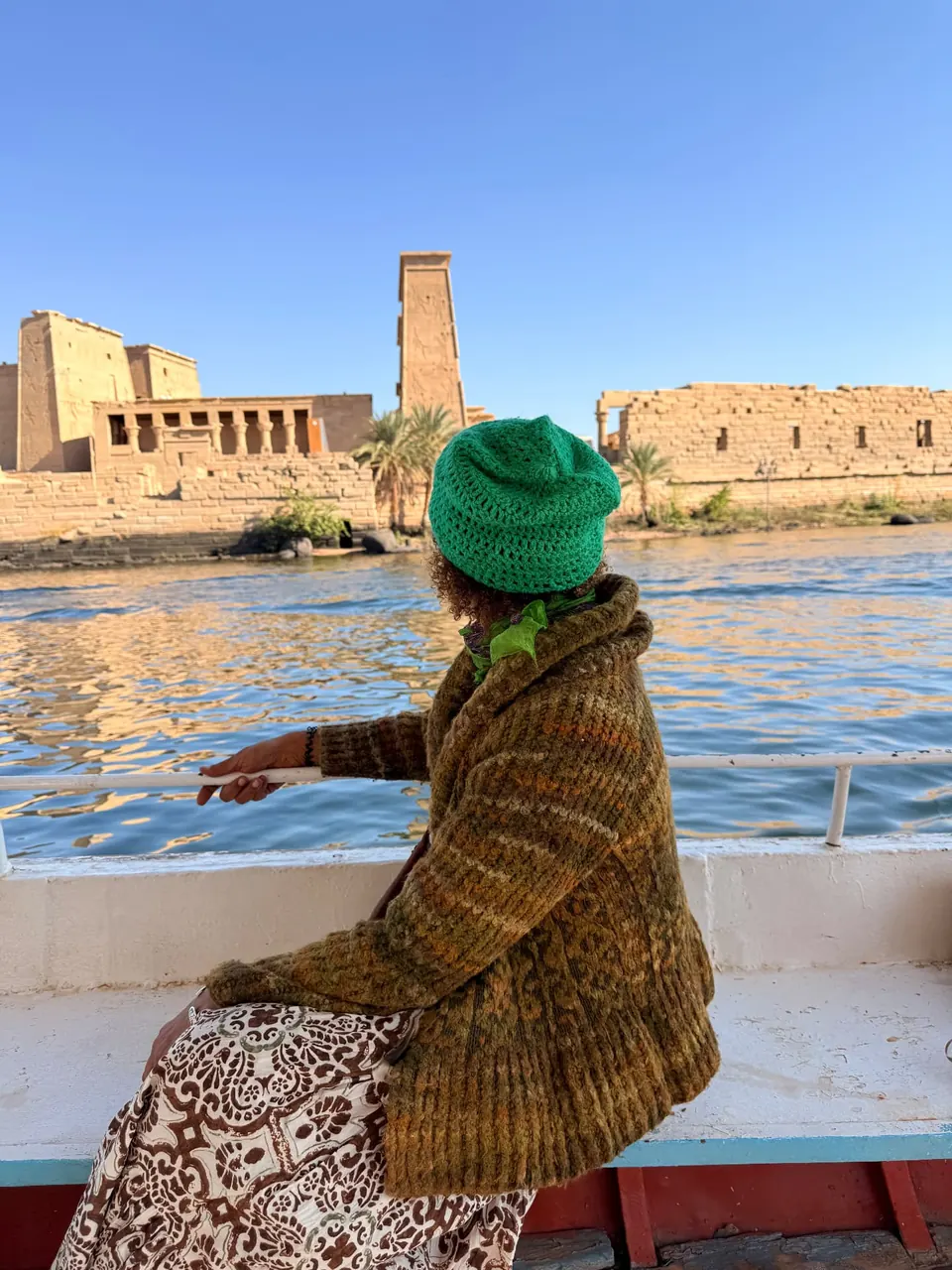 A quiet moment on a boat on the Nile, with the Temple of Auset visible across the water